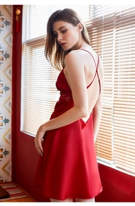 Détail de la nuisette en satin rouge montrant le dos nu et les bretelles croisées