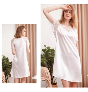 Détail de la nuisette en satin blanc avec dentelle délicate aux manches et à l'ourlet