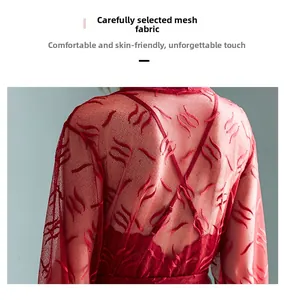 Close-up of semi-transparent red mesh fabric with embossed feather patterns and soft texture