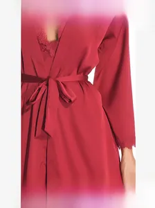 Détail du peignoir en satin de soie rouge montrant la dentelle aux poignets et au col