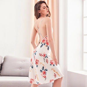 White silk satin nightgown with red rose prints and thin straps in an elegant home setting