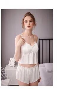 Détail d'un pyjama en soie blanche avec bordures à volants et fines bretelles