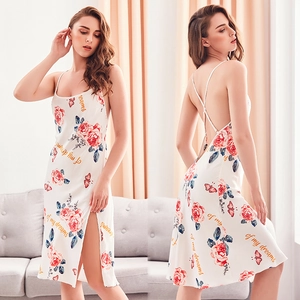 Detail view of white satin nightgown featuring floral prints and open back lace-up design