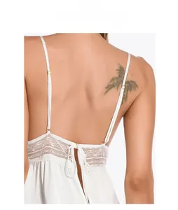 Detail of white satin nightgown with sheer lace patchwork and cross straps on back