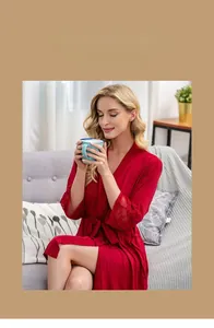 Detailed close-up of delicate lace cuffs and soft modal fabric on a dark red bathrobe
