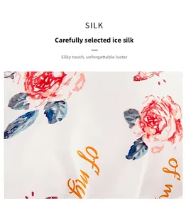 Close-up of premium ice silk satin fabric featuring red rose floral prints and art text