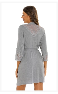 Macro detail of delicate floral lace stitching on the back and sleeves of gray modal robe