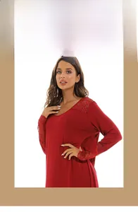 Détail d'une chemise de nuit rouge en coton avec col en V et dentelle élégante aux manches