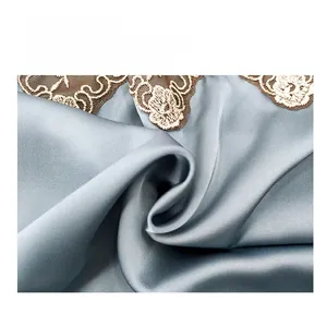 Detail of light blue faux silk satin fabric with gold lace embroidery edge