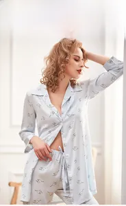 Dettaglio del pigiama azzurro effetto seta con stampe di gatti dal design minimalista