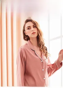 Detailed view of pink silk pajama top with V-neck collar and contrast piping trim