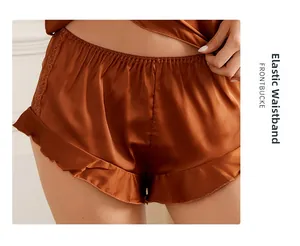 Detail of caramel satin pajamas shorts with elastic waistband and delicate lace trim