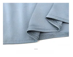 Detail of the blue silk nightgown featuring precise double-needle stitching and fabric texture