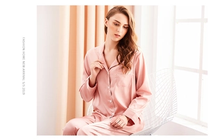 Detail of silk-satin pink pajama set with white piping and chest pocket detail