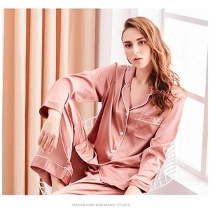 Detail of dusty pink silk satin pajamas featuring white contrast piping and chest pocket