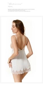 Close-up of white silk nightgown featuring delicate floral lace trim and deep V-back design