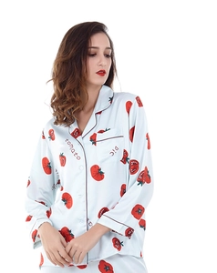 Dettaglio della maglia del pigiama in seta azzurra con stampe di pomodori e revers