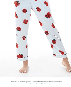 Dettaglio dei pantaloni del pigiama in raso bianco con stampa di pomodoro e bordi rossi