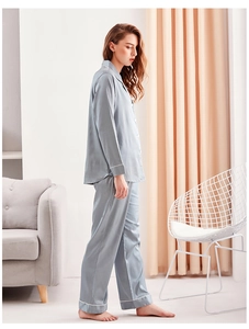 Detail of silk-like blue pajama set featuring contrast piping and elegant drape texture