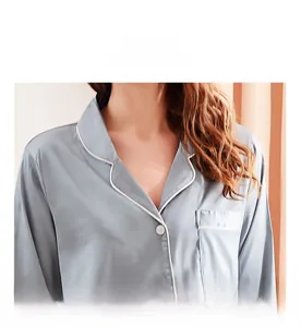 Detail of light blue silk pajamas showing V-neckline with white contrast piping trim