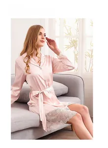Detail of elegant apricot satin robe with intricate floral lace trim on sleeves and hem