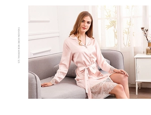 Detailed view of pink satin robe with delicate white lace cuffs and smooth fabric texture