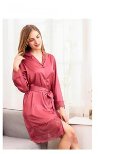 Detail of elegant rose pink satin robe featuring delicate lace trim on long sleeves