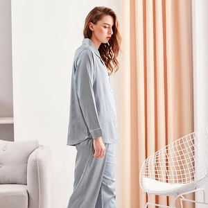 Elegant light blue silk pajama set for women with long sleeves and white piping detail