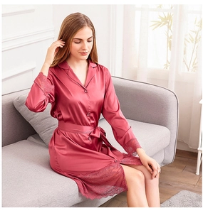 Detail of elegant satin robe with lace-trimmed sleeves and hem in dark rose red