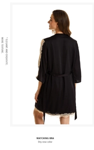 Close-up of black satin robe with beige lace trim on sleeves and silk belt detail