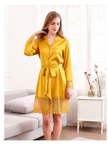 Detail of elegant yellow silk robe with delicate lace stitching on sleeves and hem