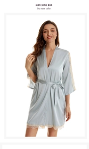 Detail of elegant satin sleepwear robe featuring lace cuffs and light blue-grey finish