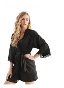 Détails d'un peignoir élégant en satin noir avec bordures en dentelle aux manches et l'ourlet