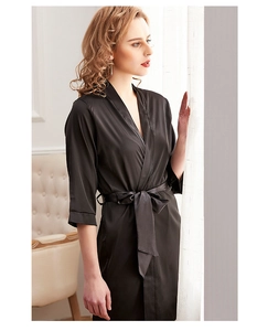 Detail of elegant black satin robe with silky texture and waist tie for women