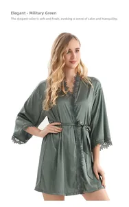 Détail d'un peignoir en satin vert armée avec bordure en dentelle grise et ceinture assortie