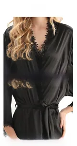 Détail de nuisette en satin noir avec dentelle délicate au col et ceinture à la taille