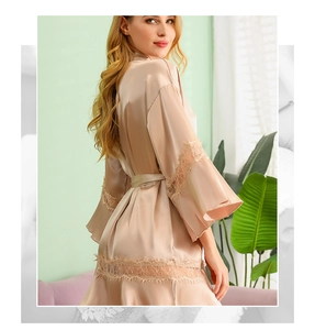 Detailed view of champagne silk bridal robe featuring delicate lace trim on cuffs and hem