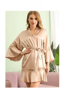 Detail of silk satin robe with delicate lace sleeve hem and elegant champagne gold sheen