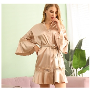 Detailed close-up of champagne satin bridal robe with delicate lace trim on the hem