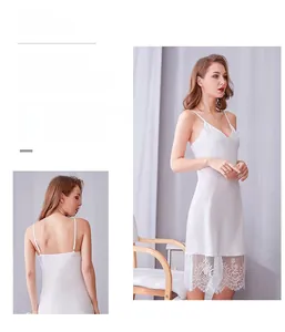 Dettaglio dell'orlo in pizzo e del tessuto satinato della camicia da notte bianca in seta