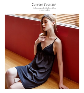 Detail view of black satin sleepwear with delicate lace trim on the deep V-neckline