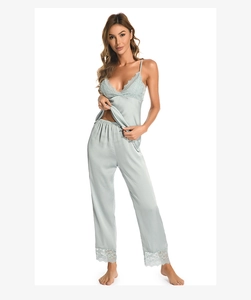 Close-up of sage green silk pajama set with delicate lace trim on V-neck and hemline