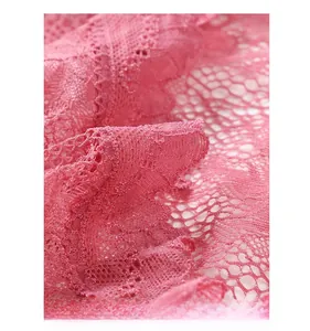 Dettaglio dell'orlo in pizzo floreale rosa con intricati motivi a rete traforata