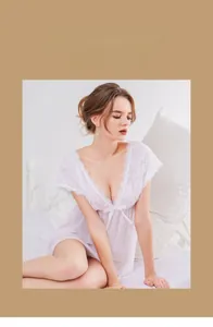 Detail of white lace V-neck nightdress with semi-transparent mesh and floral trim