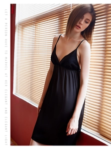 Detail of elegant black silk nightdress featuring V-neckline with delicate floral lace trim