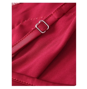 Detail of adjustable silver metal buckle on red satin lingerie shoulder strap
