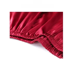 Detailed macro view of elastic waist pleats and fine stitching on red satin loungewear