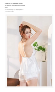 Detail eines weißen Seidenpyjama-Sets mit feiner Spitze an V-Ausschnitt Top und Shorts