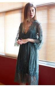 Close-up of deep green floral lace details on a sheer robe with flared sleeves