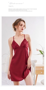Detail eines dunkelroten Satin-Nachthemds mit feiner floraler Spitze am V-Ausschnitt
